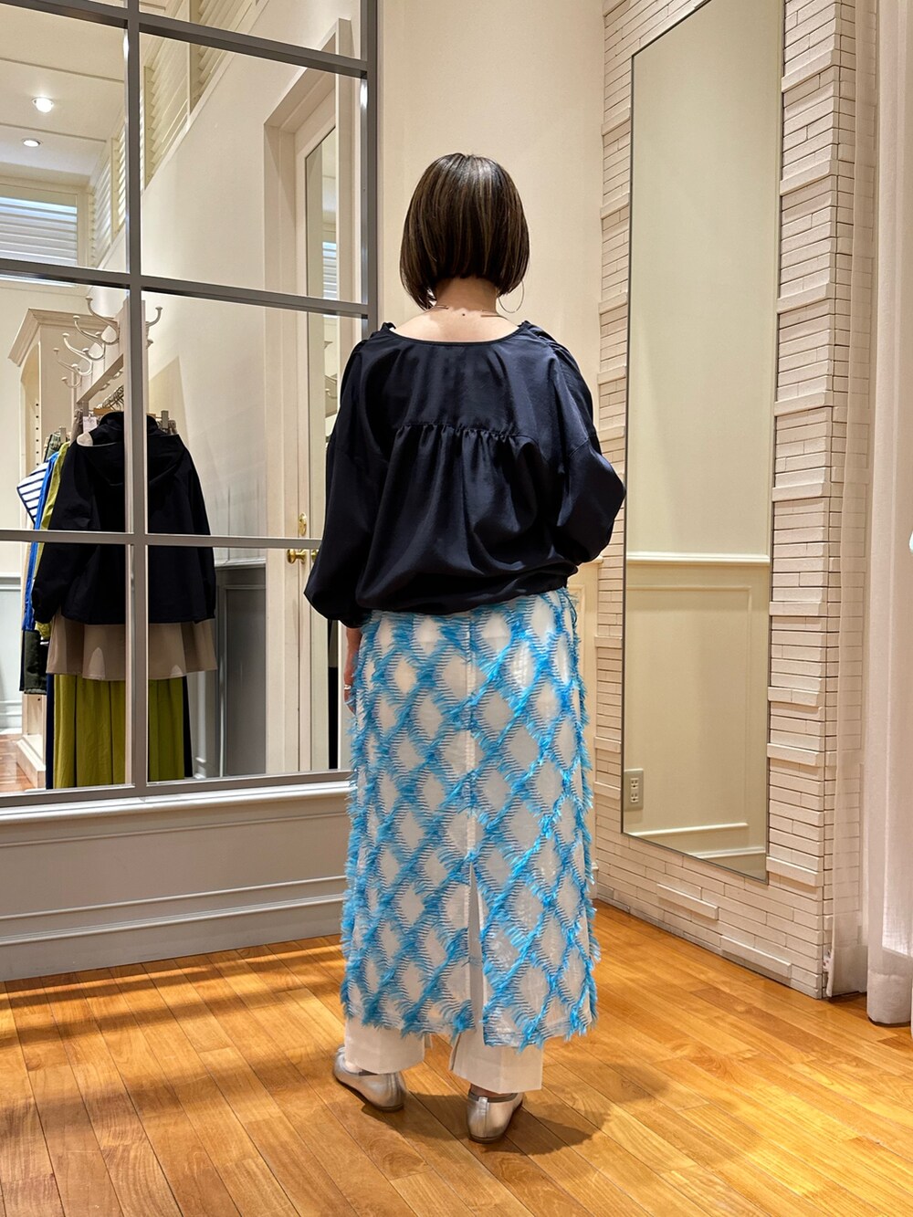 ホワイト系のデニムパンツ、ブルー系のスカート、ホワイト系のタンクトップを着用したレディースの春コーディネートの4枚目の写真