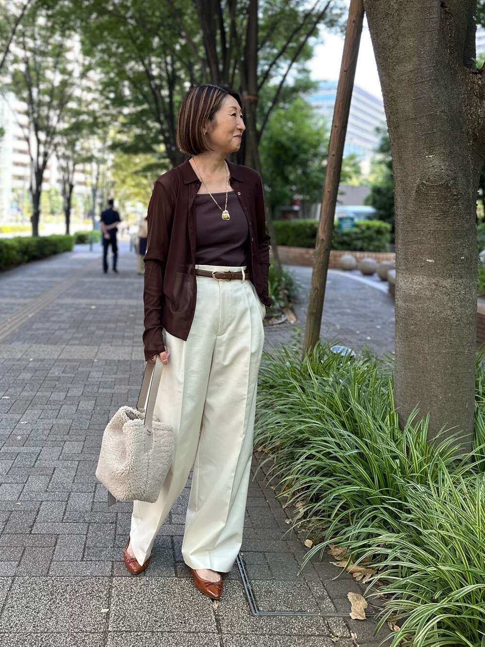 ブラウン系のカーディガン/ボレロ、ブラウン系のタンクトップ、ホワイト系のその他パンツを着用したレディースの秋コーディネートの3枚目の写真