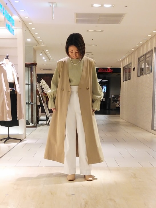 ベージュ系のトレンチコート、グリーン系のシャツ/ブラウス、ホワイト系のその他パンツを着用したレディースの春コーディネートの2枚目の写真