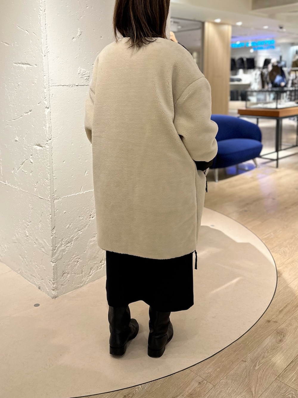 ホワイト系のダウンジャケット/コート、ブラック系のワンピース、ホワイト系のニット/セーターを着用したレディースの秋コーディネートの3枚目の写真