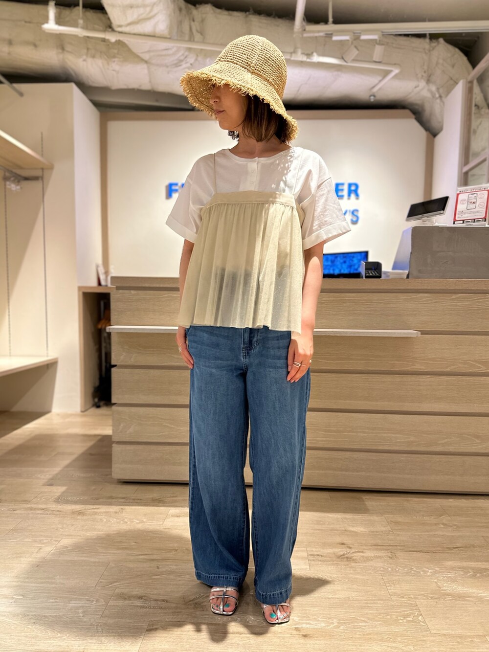 ブルー系のデニムパンツ、ホワイト系のTシャツ/カットソー、ベージュ系のシャツ/ブラウスを着用したレディースの夏コーディネートの3枚目の写真