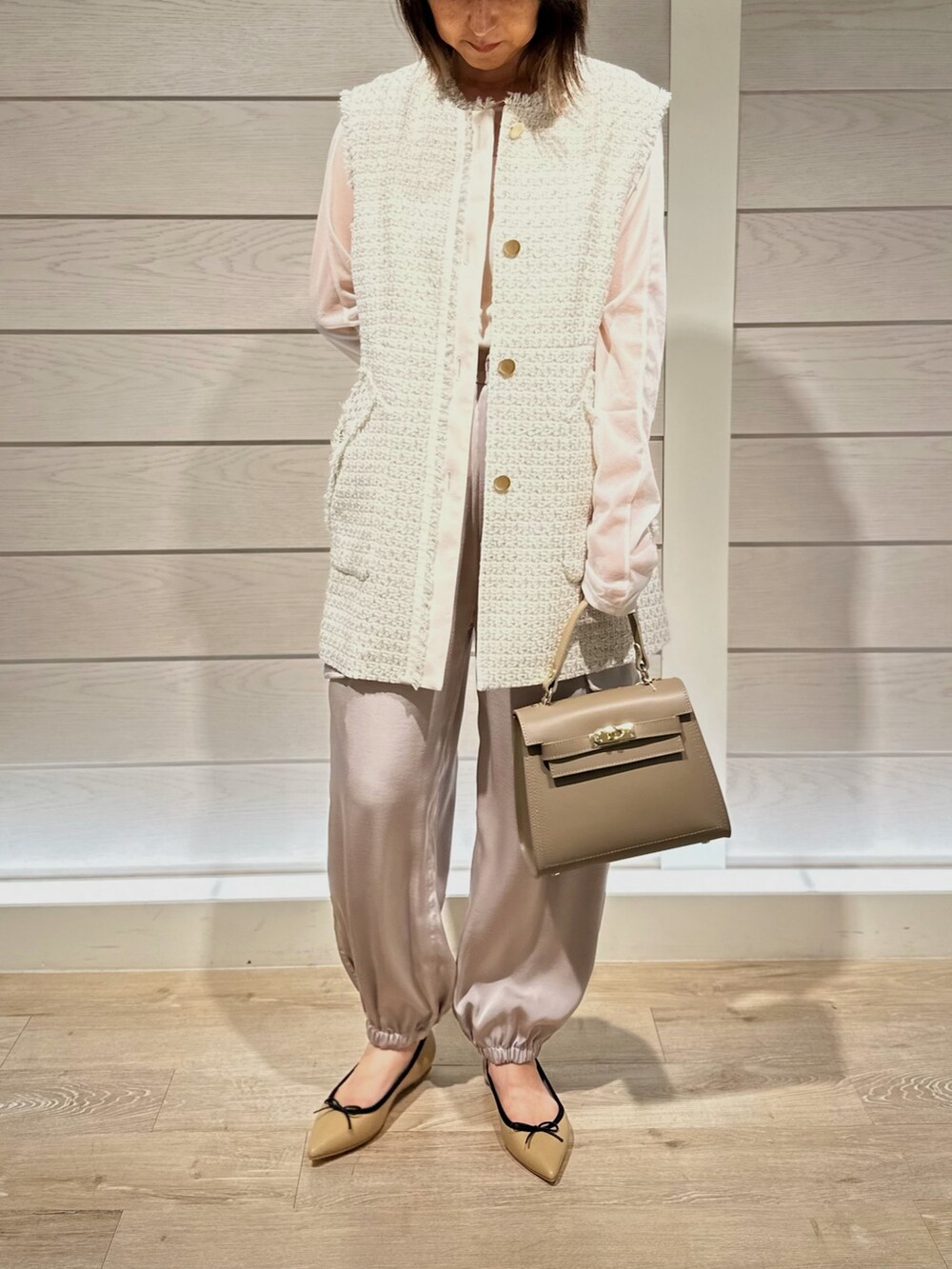 ベージュ系のショルダーバッグ、ベージュ系のパンプス、ベージュ系のカーゴパンツを着用したレディースの秋コーディネートの3枚目の写真