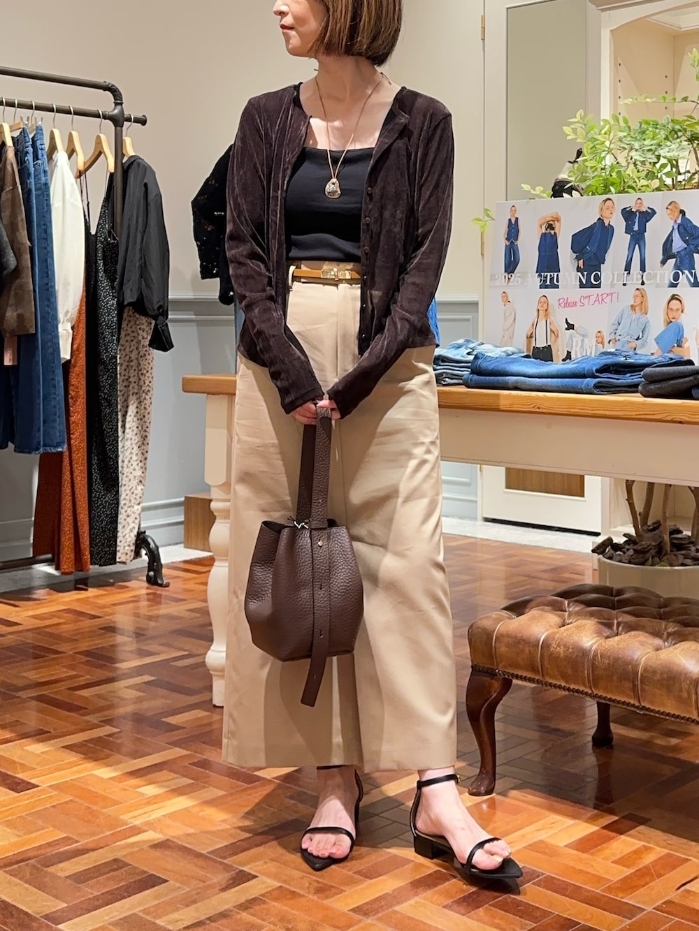 ベージュ系のスカート、ブラウン系のショルダーバッグ、ブラウン系のカーディガン/ボレロを着用したレディースの秋コーディネートの7枚目の写真