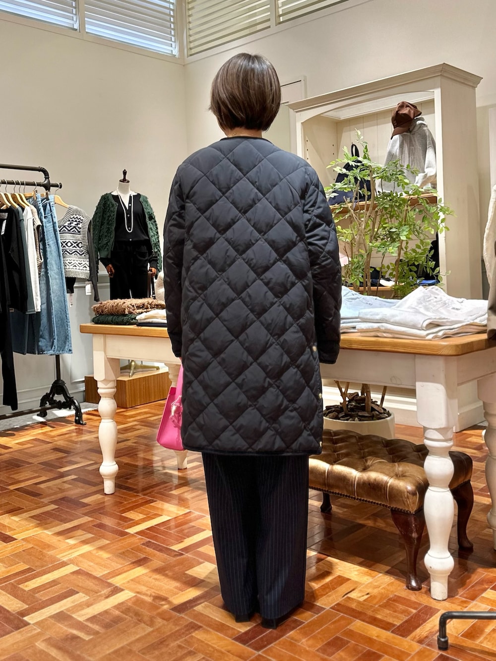 ブラック系のダウンジャケット/コート、グレー系のニット/セーター、ブルー系のその他パンツを着用したレディースの秋コーディネートの5枚目の写真