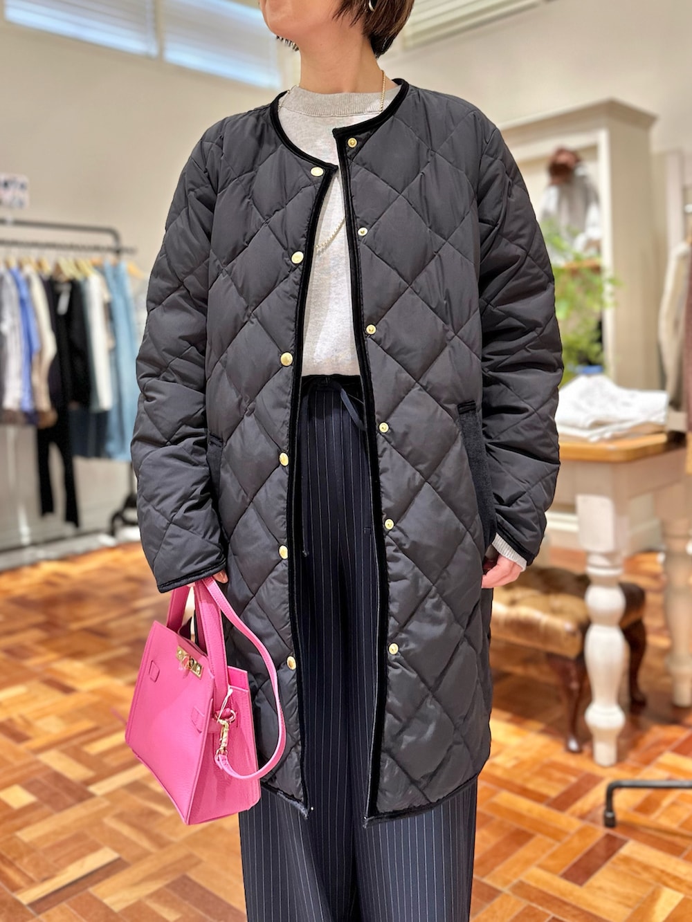 ブラック系のダウンジャケット/コート、グレー系のニット/セーター、ブルー系のその他パンツを着用したレディースの秋コーディネートの3枚目の写真