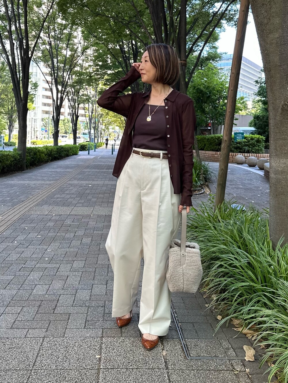 ブラウン系のカーディガン/ボレロ、ブラウン系のタンクトップ、ホワイト系のその他パンツを着用したレディースの秋コーディネートの4枚目の写真