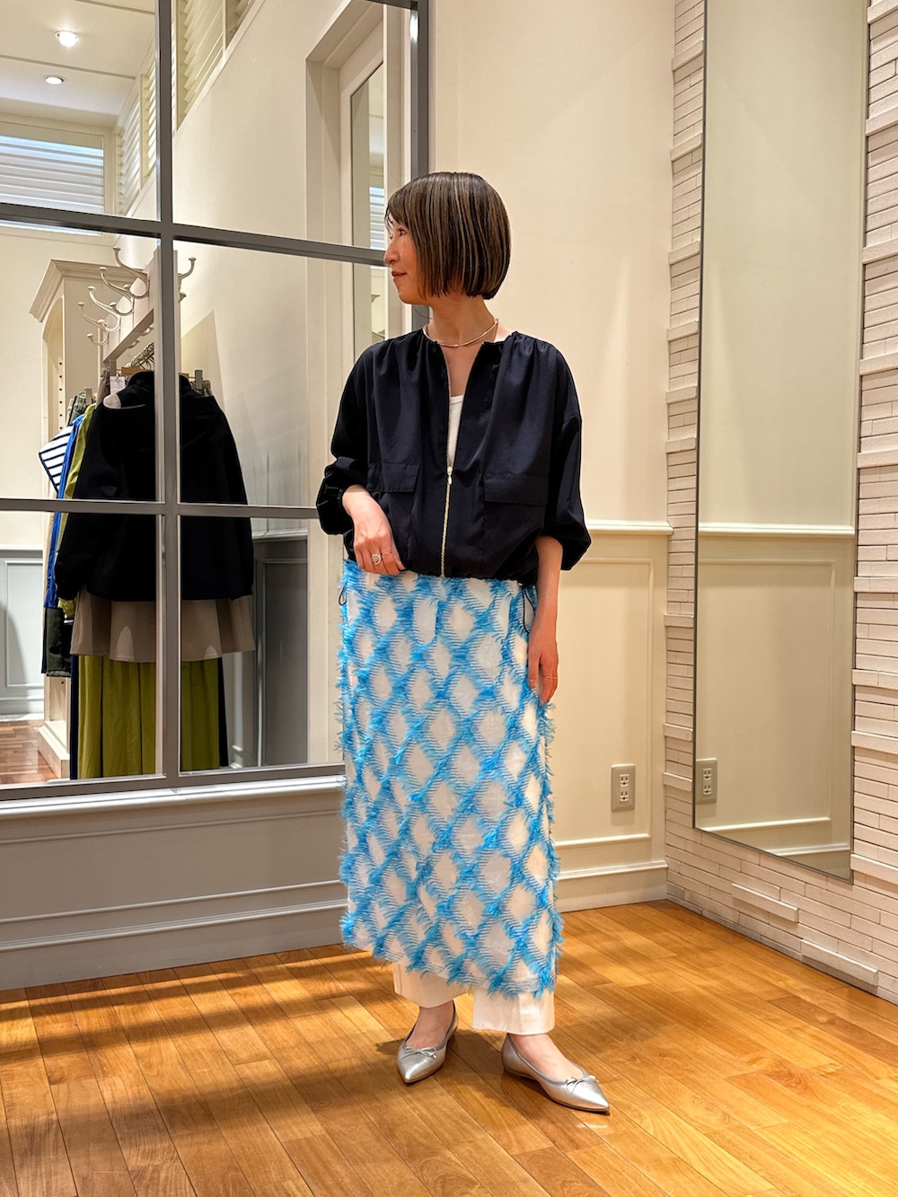 ホワイト系のデニムパンツ、ブルー系のスカート、ホワイト系のタンクトップを着用したレディースの春コーディネートの3枚目の写真