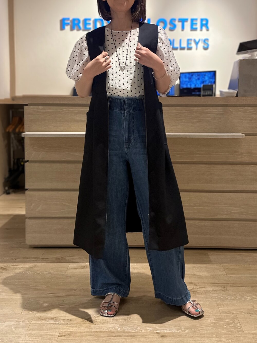 ホワイト系のシャツ/ブラウス、シルバー系のサンダル、ブルー系のデニムパンツを着用したレディースの夏コーディネートの3枚目の写真