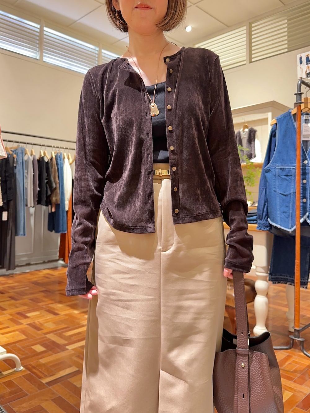 ベージュ系のスカート、ブラウン系のショルダーバッグ、ブラウン系のカーディガン/ボレロを着用したレディースの秋コーディネートの6枚目の写真