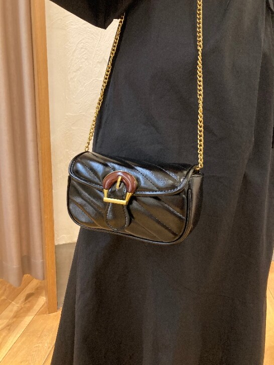 ブラック系のワンピース、ブラック系のショルダーバッグ、ベージュ系のサンダルを着用したレディースの春コーディネートの3枚目の写真