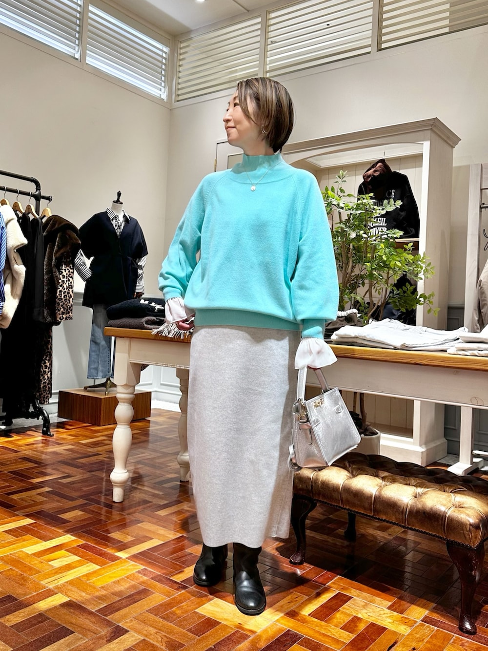 グレー系のスカート、シルバー系のショルダーバッグ、ホワイト系のシャツ/ブラウスを着用したレディースの秋コーディネートの2枚目の写真