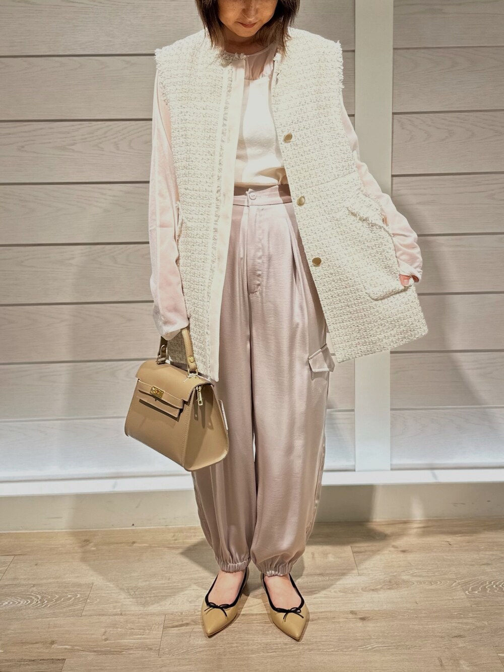 ベージュ系のショルダーバッグ、ベージュ系のパンプス、ベージュ系のカーゴパンツを着用したレディースの秋コーディネートの2枚目の写真