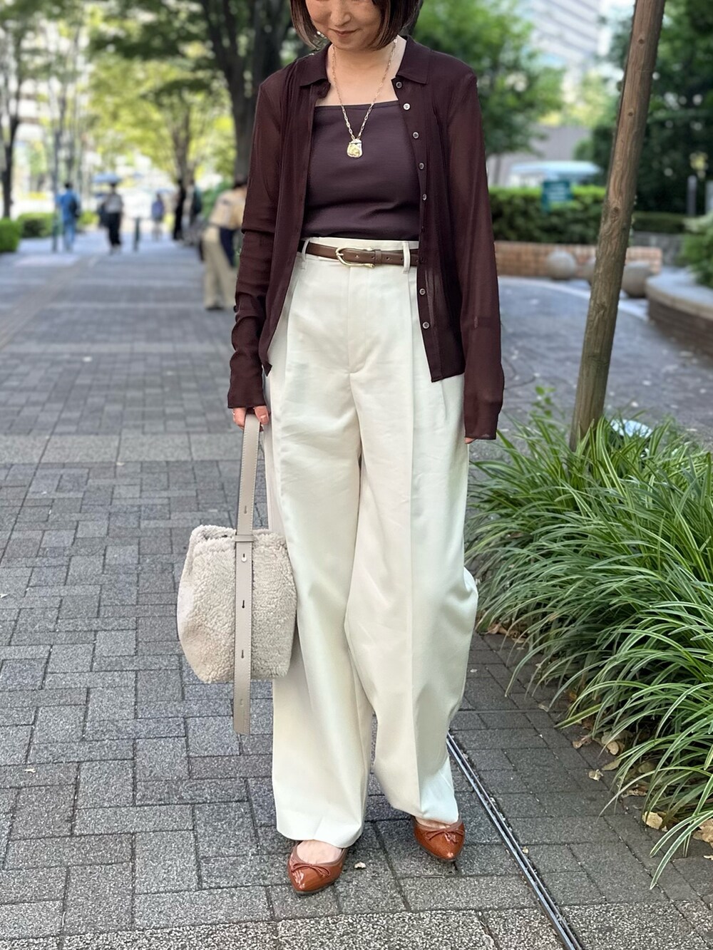 ブラウン系のカーディガン/ボレロ、ブラウン系のタンクトップ、ホワイト系のその他パンツを着用したレディースの秋コーディネートの5枚目の写真