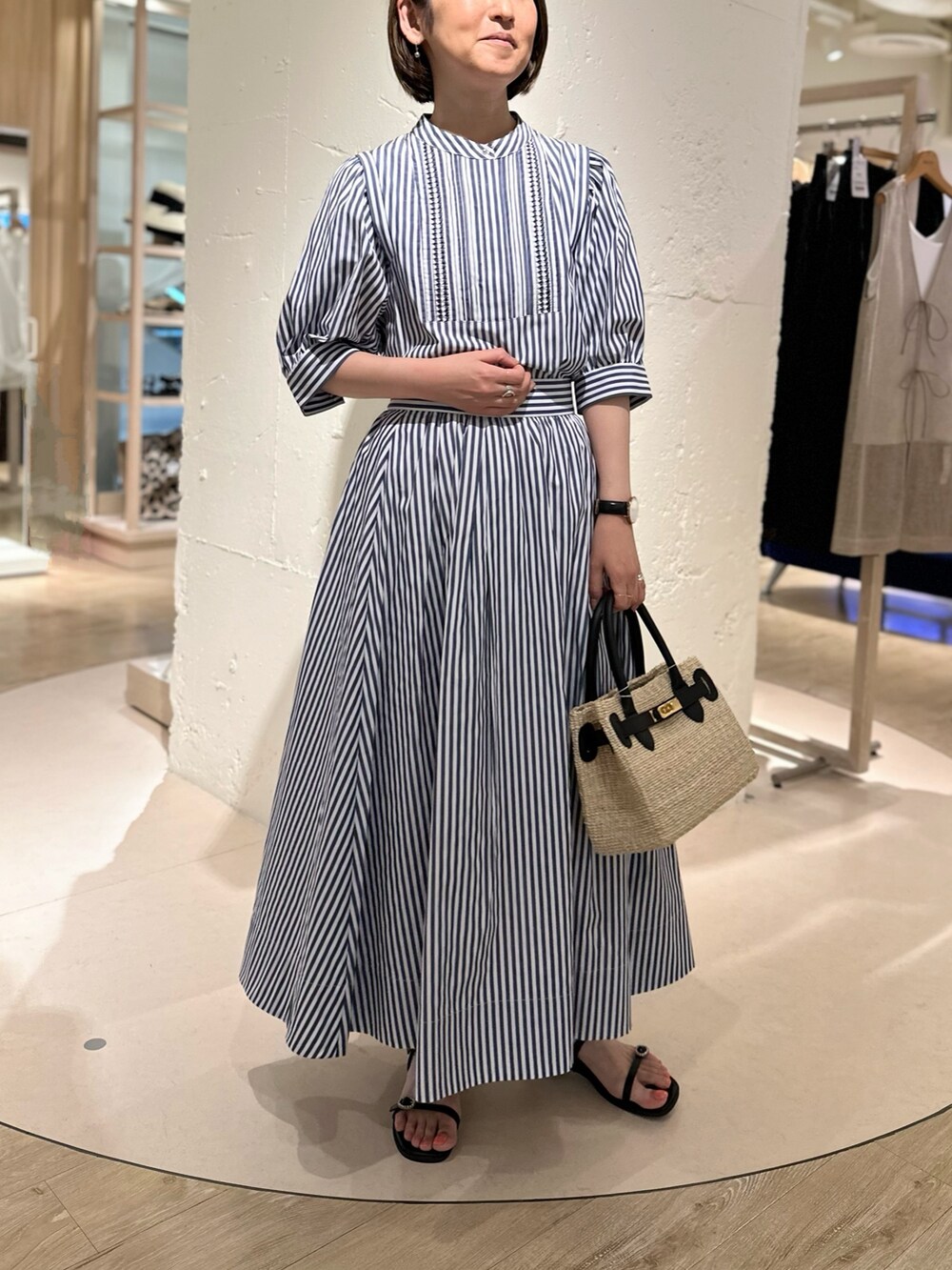 ホワイト系のシャツ/ブラウス、ホワイト系のスカート、ブラック系のかごバッグを着用したレディースの夏コーディネートの2枚目の写真