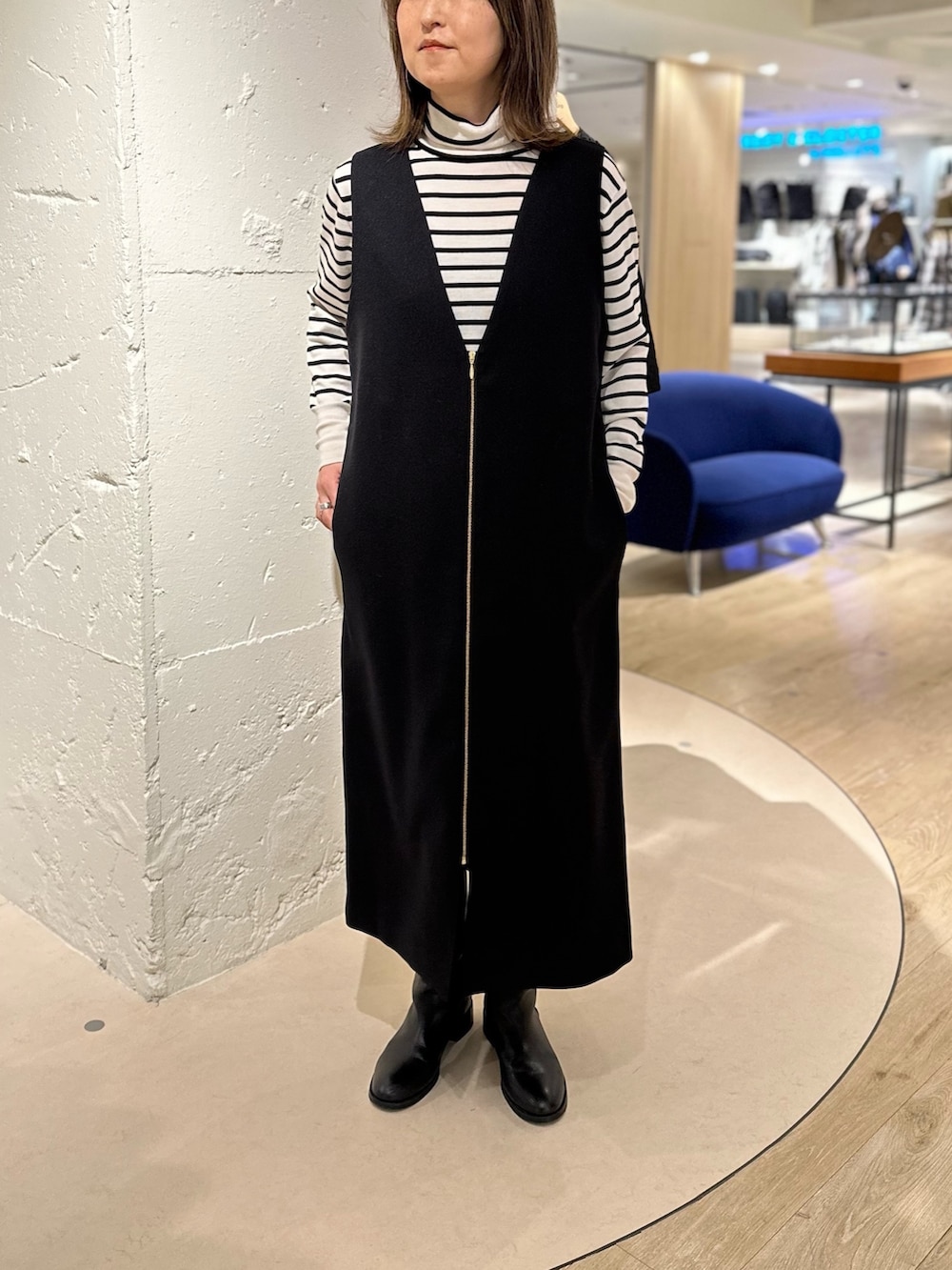 ホワイト系のダウンジャケット/コート、ブラック系のワンピース、ホワイト系のニット/セーターを着用したレディースの秋コーディネートの4枚目の写真