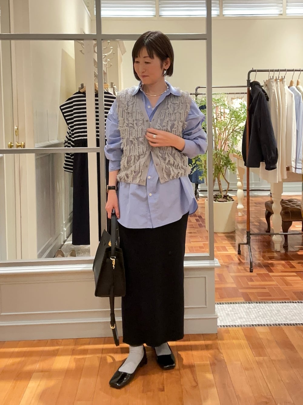 「春コーデ、春服コーデ、レディースファッション、シアー、シャツスタイル、ブルーシャツ、ベスト、ベスト×シャツ、ベストコーデ、オフィスカジュアル、スカート、スカートスタイル、ニットスカート、タイトスカート、ショルダーバッグ」｜「NOLLEY’Sの《アンサンブル対応》《手洗い可能》カットフリンジ2WAYベスト（ベスト、グレー系）」を使った、Yamazakiさん（レディース・157cm）の春コーディネートの3枚目の写真