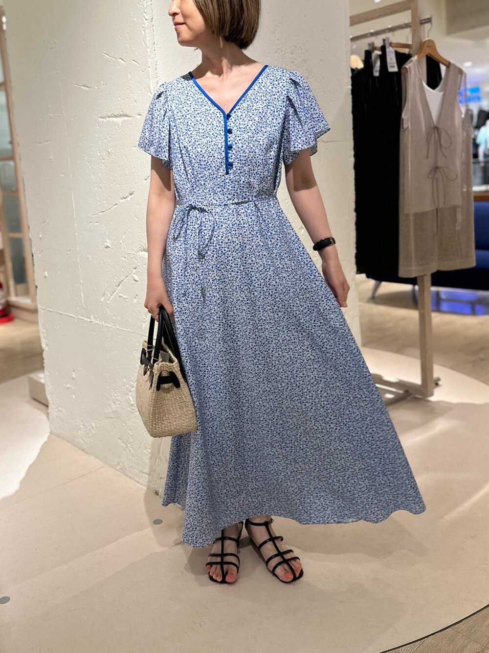 ブラック系のかごバッグ、ブルー系のカーディガン/ボレロ、ブルー系のワンピースを着用したレディースの夏コーディネートの3枚目の写真