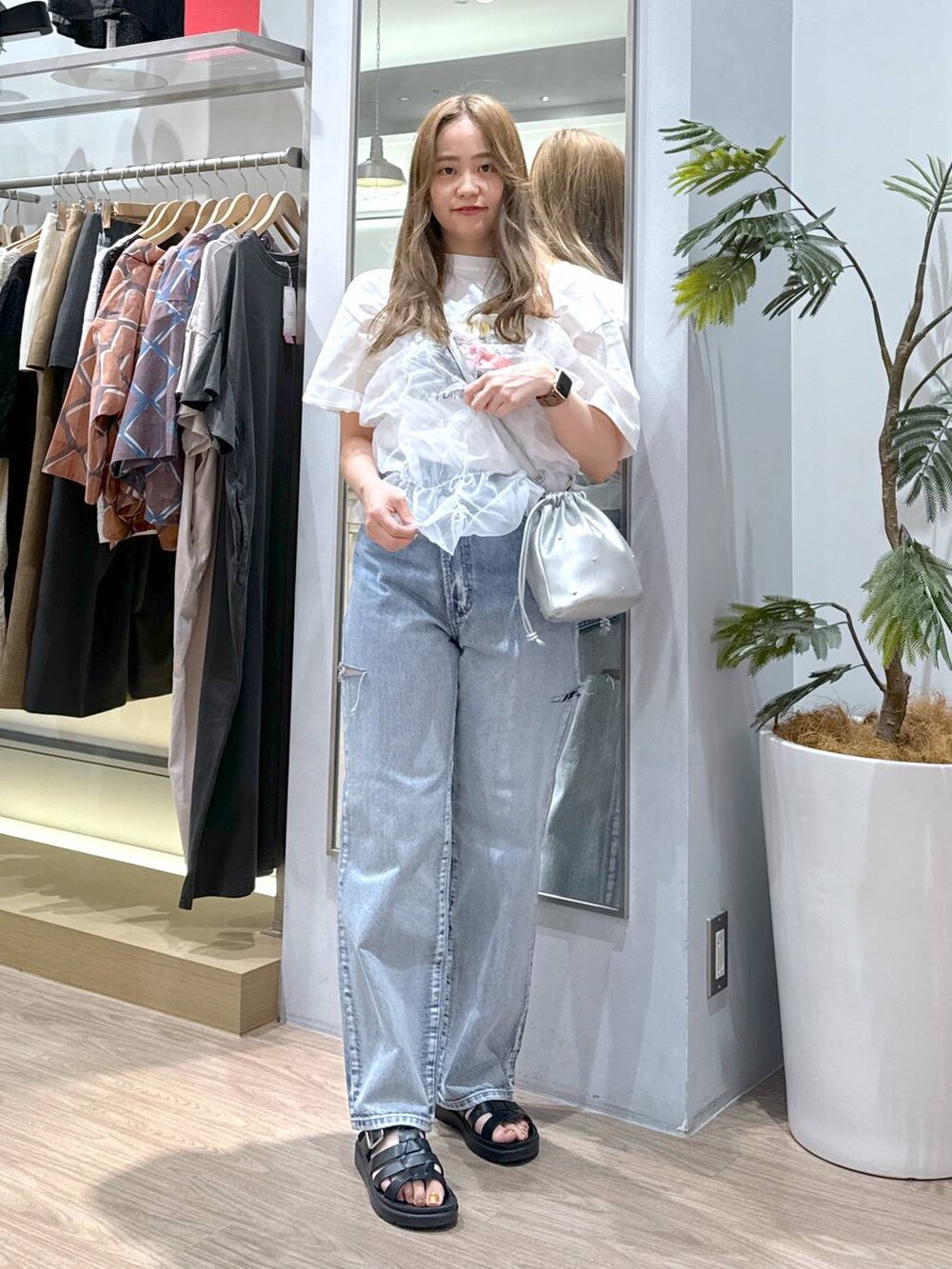 シルバー系のショルダーバッグ、ホワイト系のTシャツ/カットソー、ブラック系のスニーカーを着用したレディースの夏コーディネートの3枚目の写真