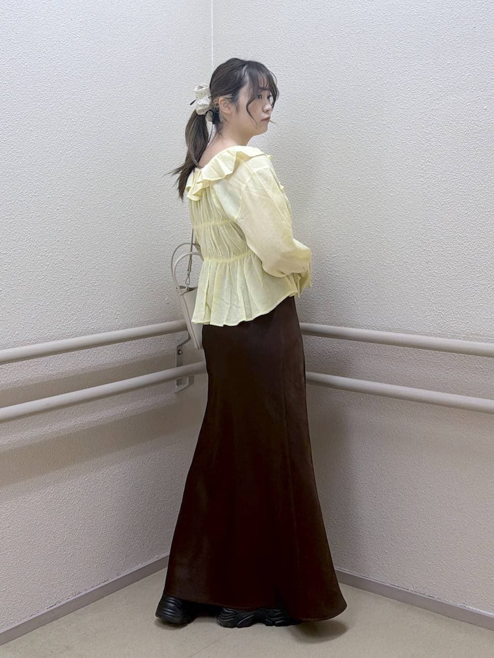 ブラウン系のスカート、ホワイト系のショルダーバッグ、イエロー系のシャツ/ブラウスを着用したレディースの春コーディネートの4枚目の写真