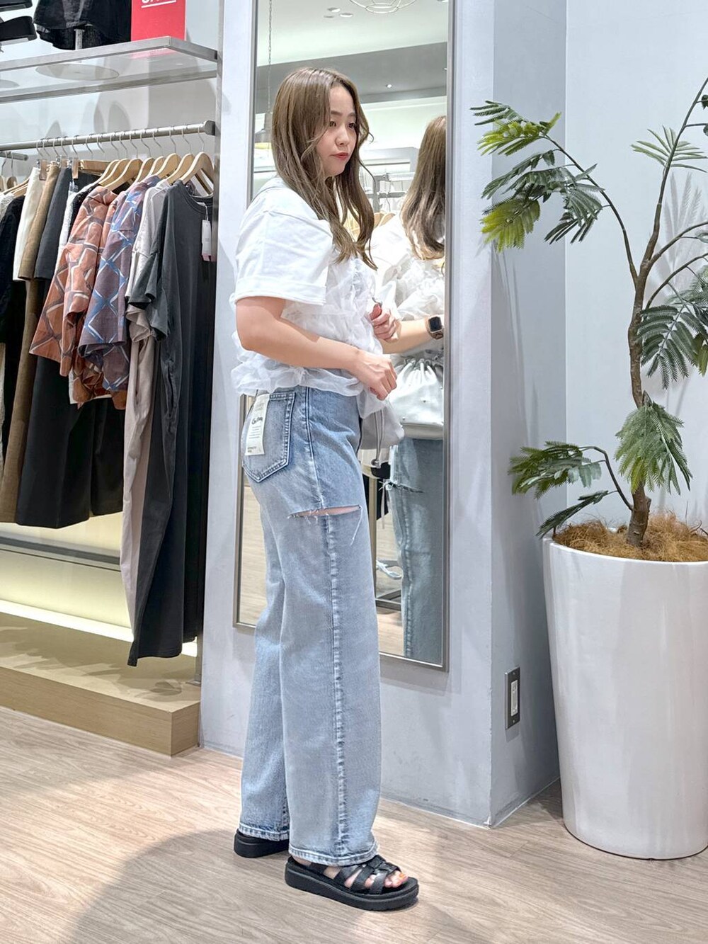 シルバー系のショルダーバッグ、ホワイト系のTシャツ/カットソー、ブラック系のスニーカーを着用したレディースの夏コーディネートの2枚目の写真