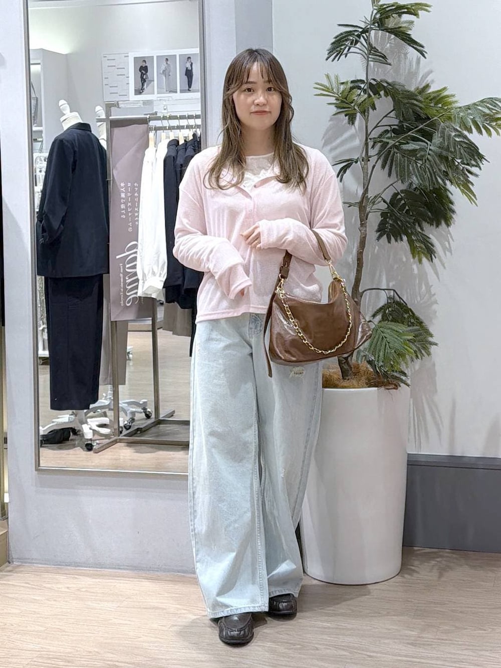 ブルー系のデニムパンツ、ホワイト系のTシャツ/カットソー、ブラウン系のショルダーバッグを着用したレディースの冬コーディネートの3枚目の写真