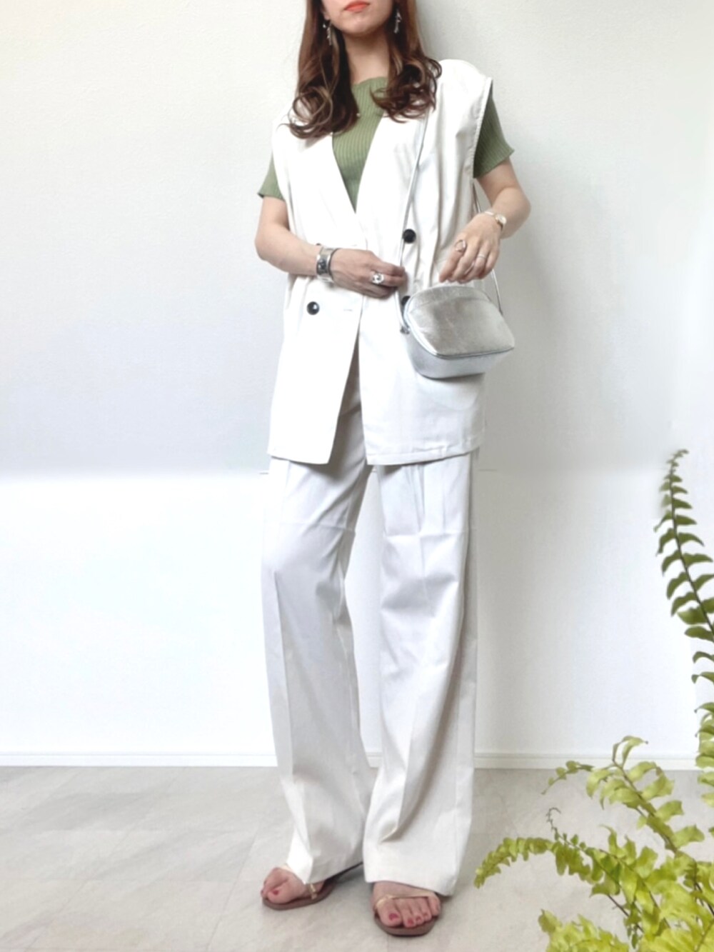 ホワイト系のセットアップ、ブラック系のサンダル、シルバー系のショルダーバッグを着用したレディースの春コーディネートの2枚目の写真