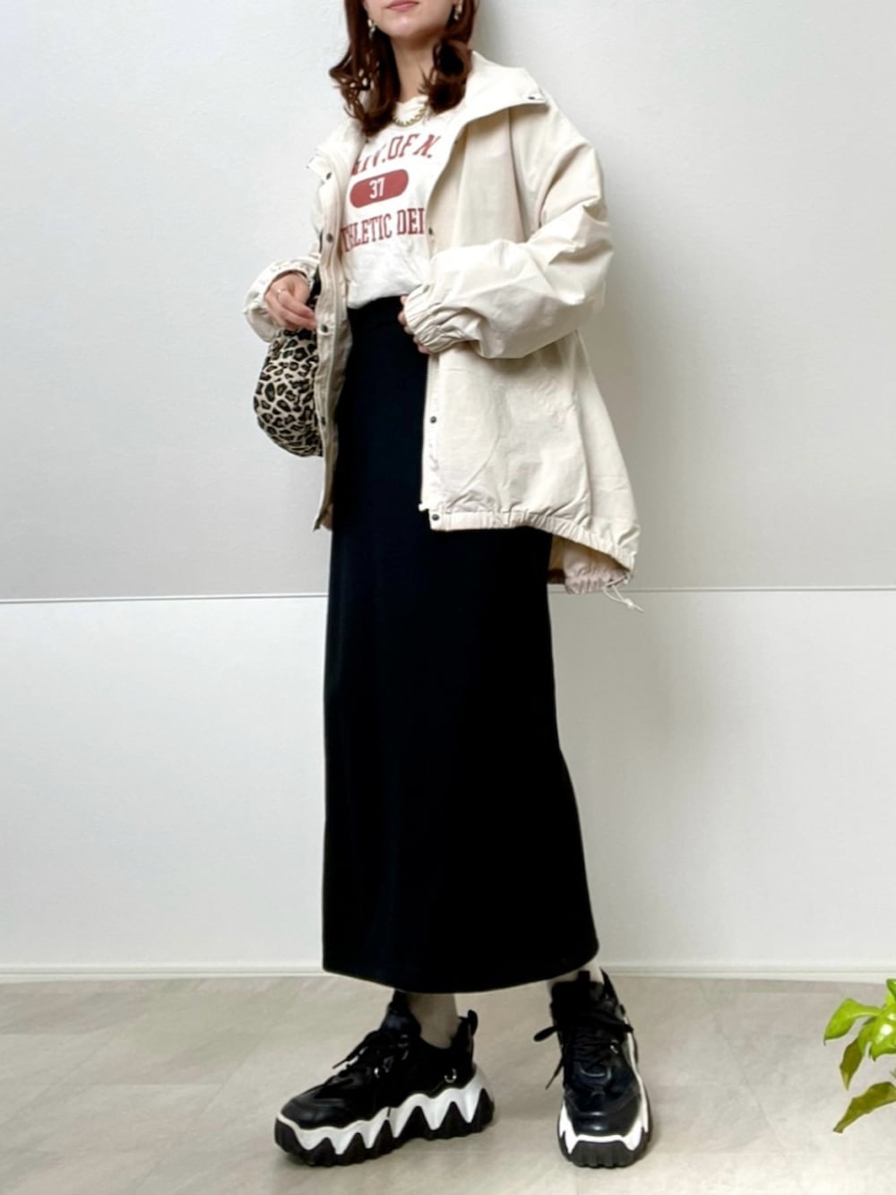 ホワイト系のナイロンジャケット、ベージュ系のTシャツ/カットソー、ブラック系のスニーカーを着用したレディースの春コーディネートの2枚目の写真