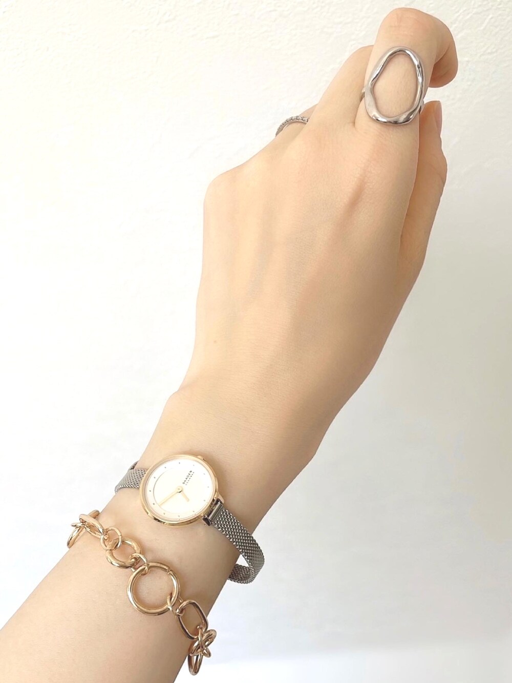 ホワイト系のセットアップ、ブラック系のサンダル、シルバー系のショルダーバッグを着用したレディースの春コーディネートの3枚目の写真