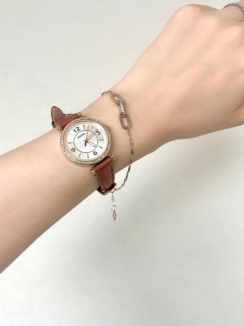 グレー系のドレス、ブラック系のバッグ、ゴールド系のブレスレットを着用したレディースの秋コーディネートの2枚目の写真