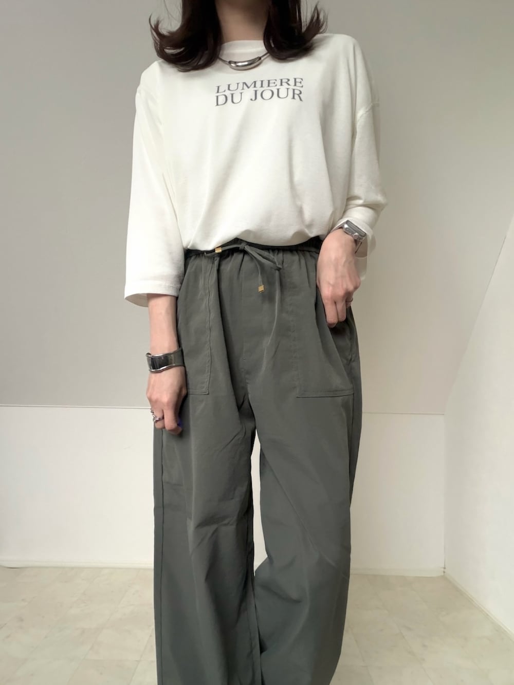 ホワイト系のアンサンブル、グリーン系のブルゾン、グリーン系のカーゴパンツを着用したレディースの春コーディネートの2枚目の写真