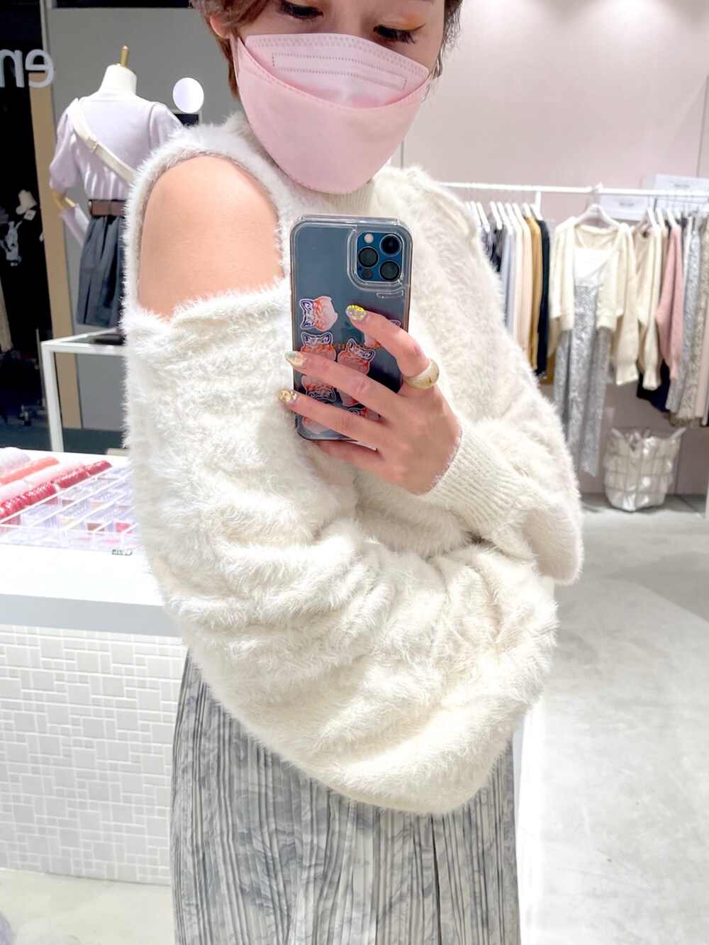 ホワイト系のニット/セーター、グレー系のスカートを着用したレディースの秋コーディネートの2枚目の写真