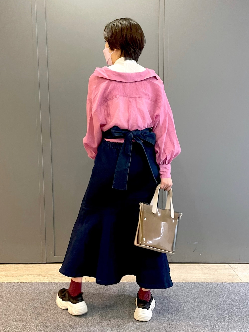 ピンク系のシャツ/ブラウス、ブルー系のスカート、ブラック系のスニーカーを着用したレディースの春コーディネートの3枚目の写真