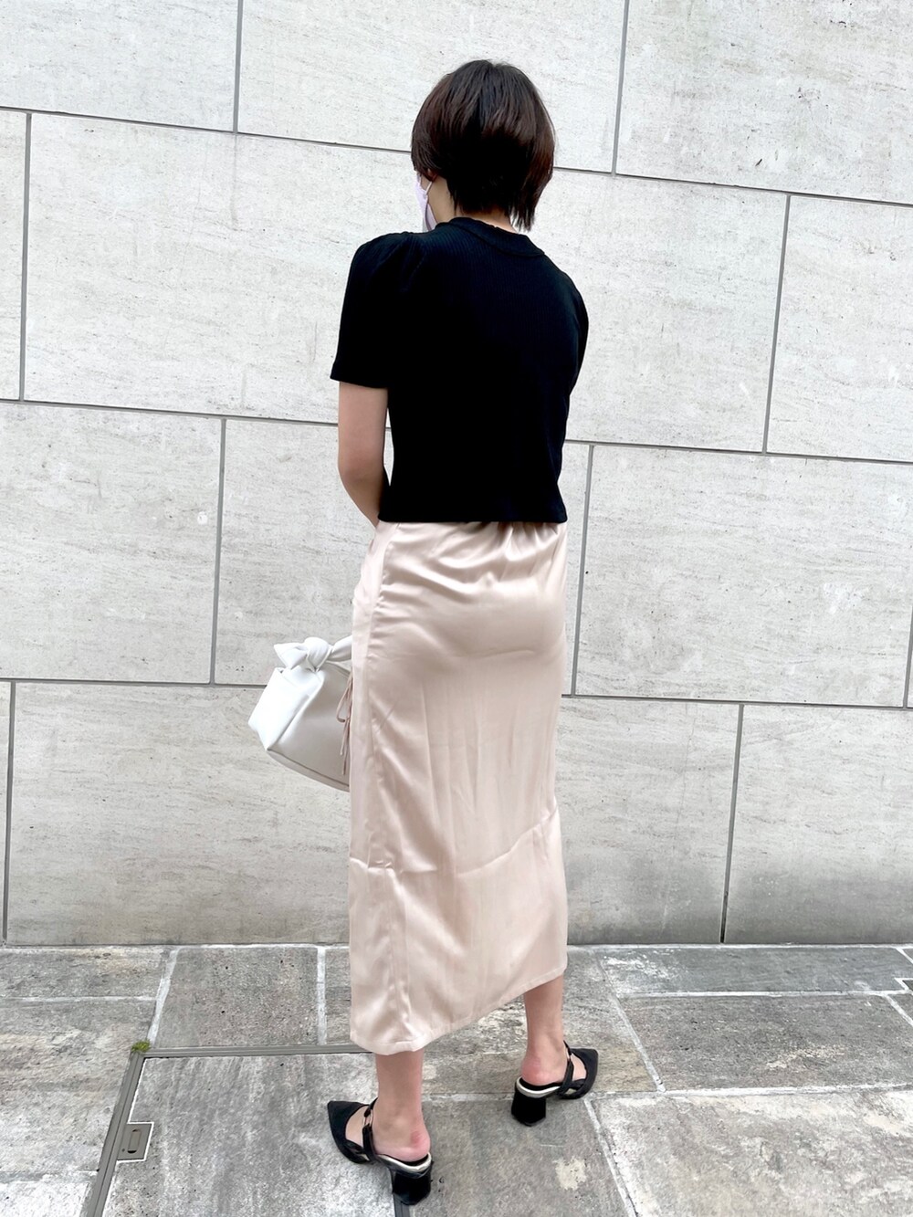 ブラック系のTシャツ/カットソー、ホワイト系のスカート、ホワイト系のショルダーバッグを着用したレディースの夏コーディネートの3枚目の写真