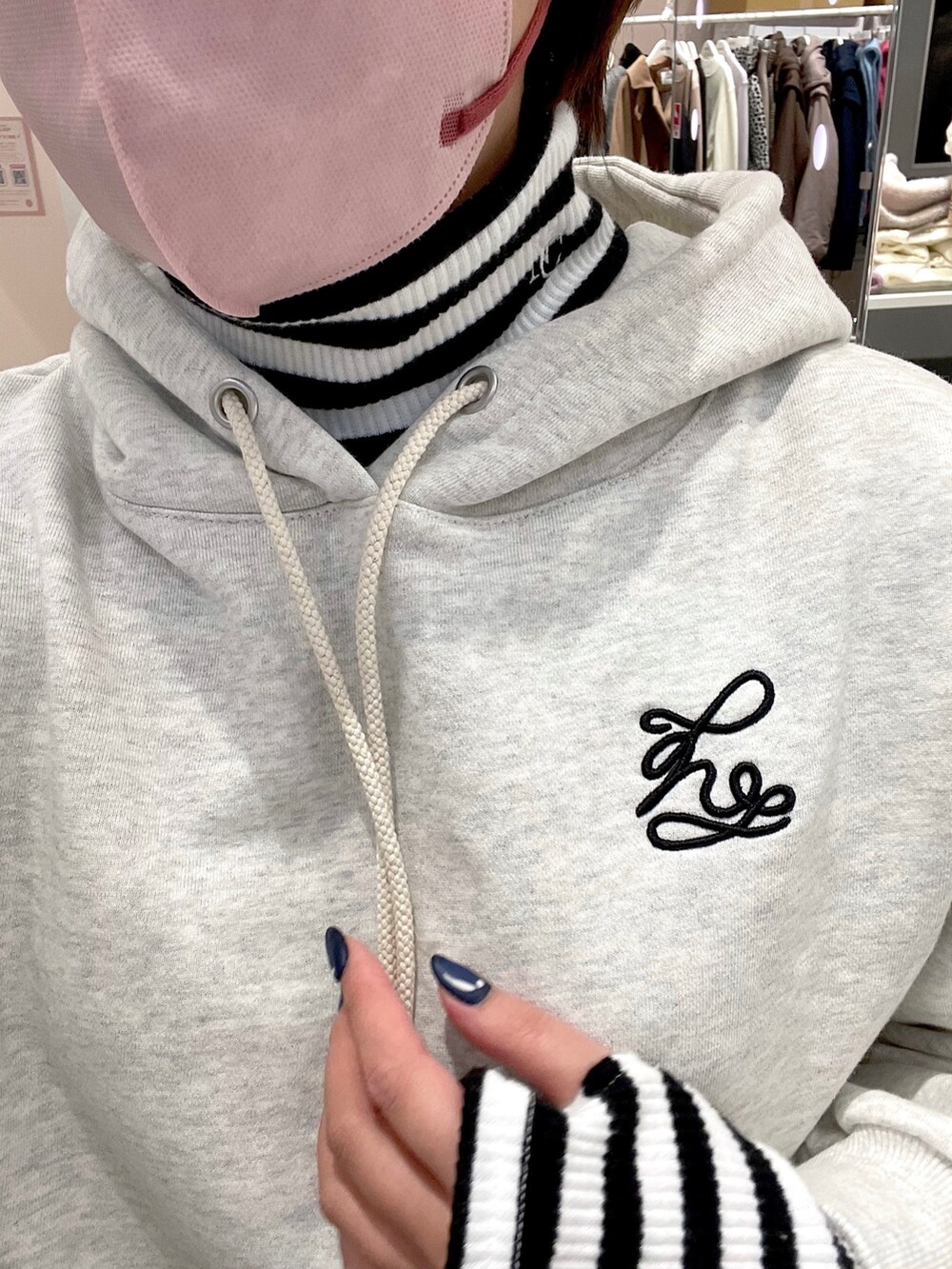 ベージュ系のパーカー、ブラック系のTシャツ/カットソー、ブラック系のスカートを着用したレディースの冬コーディネートの2枚目の写真