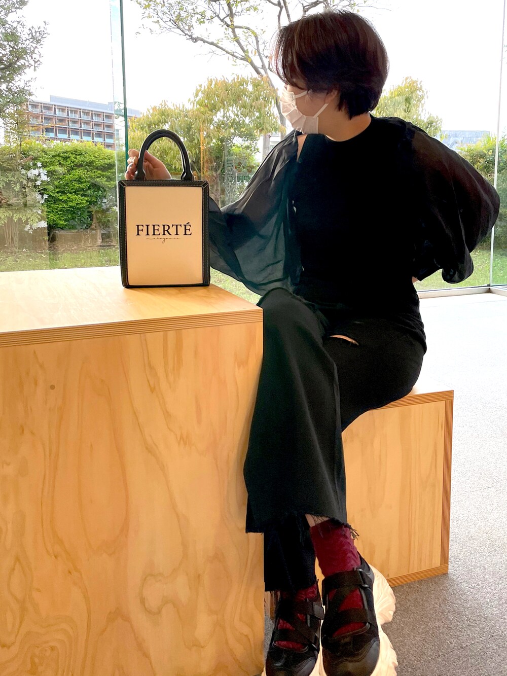 ブラック系のアンサンブル、ブラック系のデニムパンツ、ブラック系のショルダーバッグを着用したレディースの春コーディネートの3枚目の写真