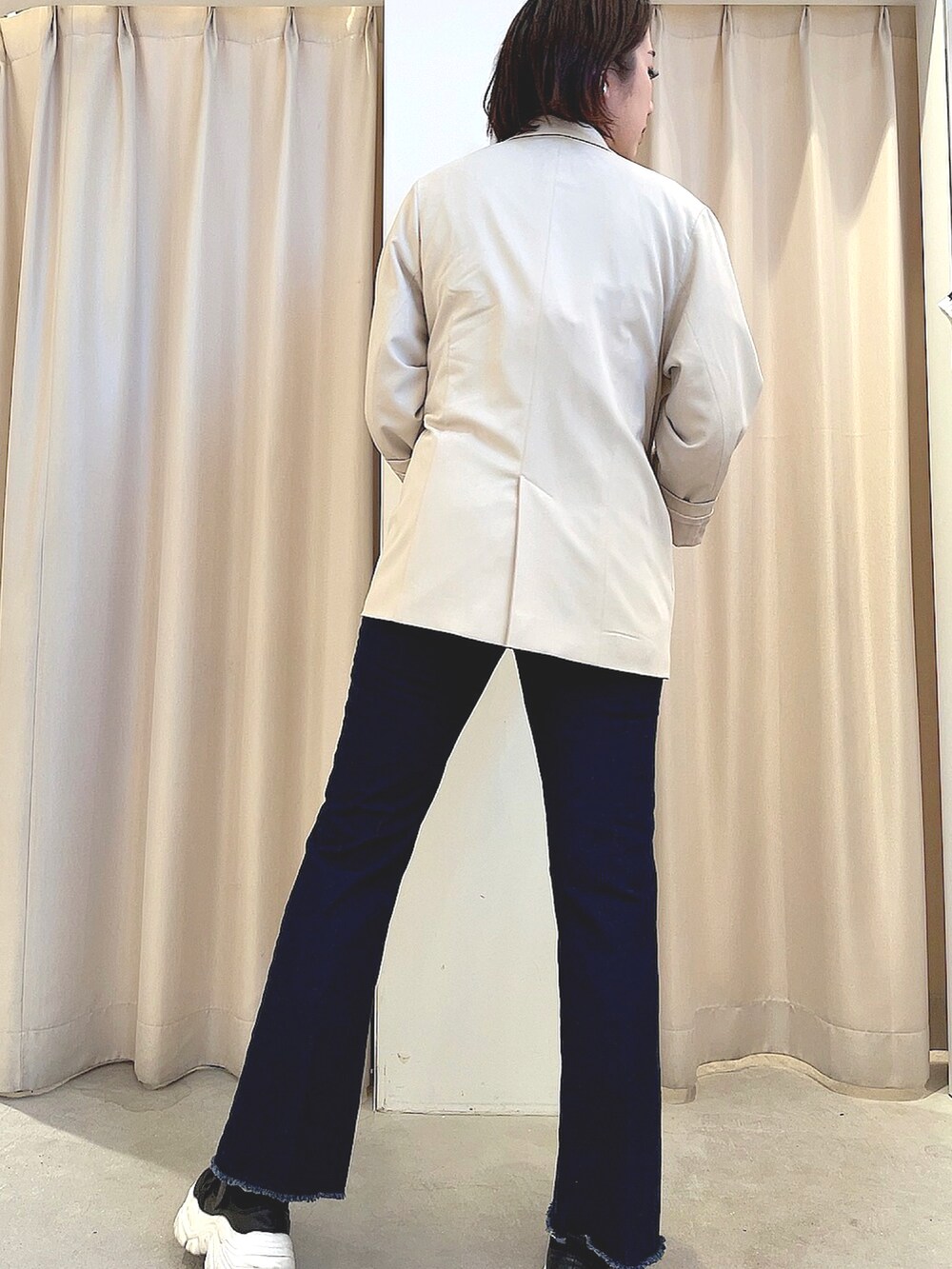 ベージュ系のニット/セーター、ホワイト系のTシャツ/カットソー、ブルー系のデニムパンツを着用したレディースの春コーディネートの2枚目の写真