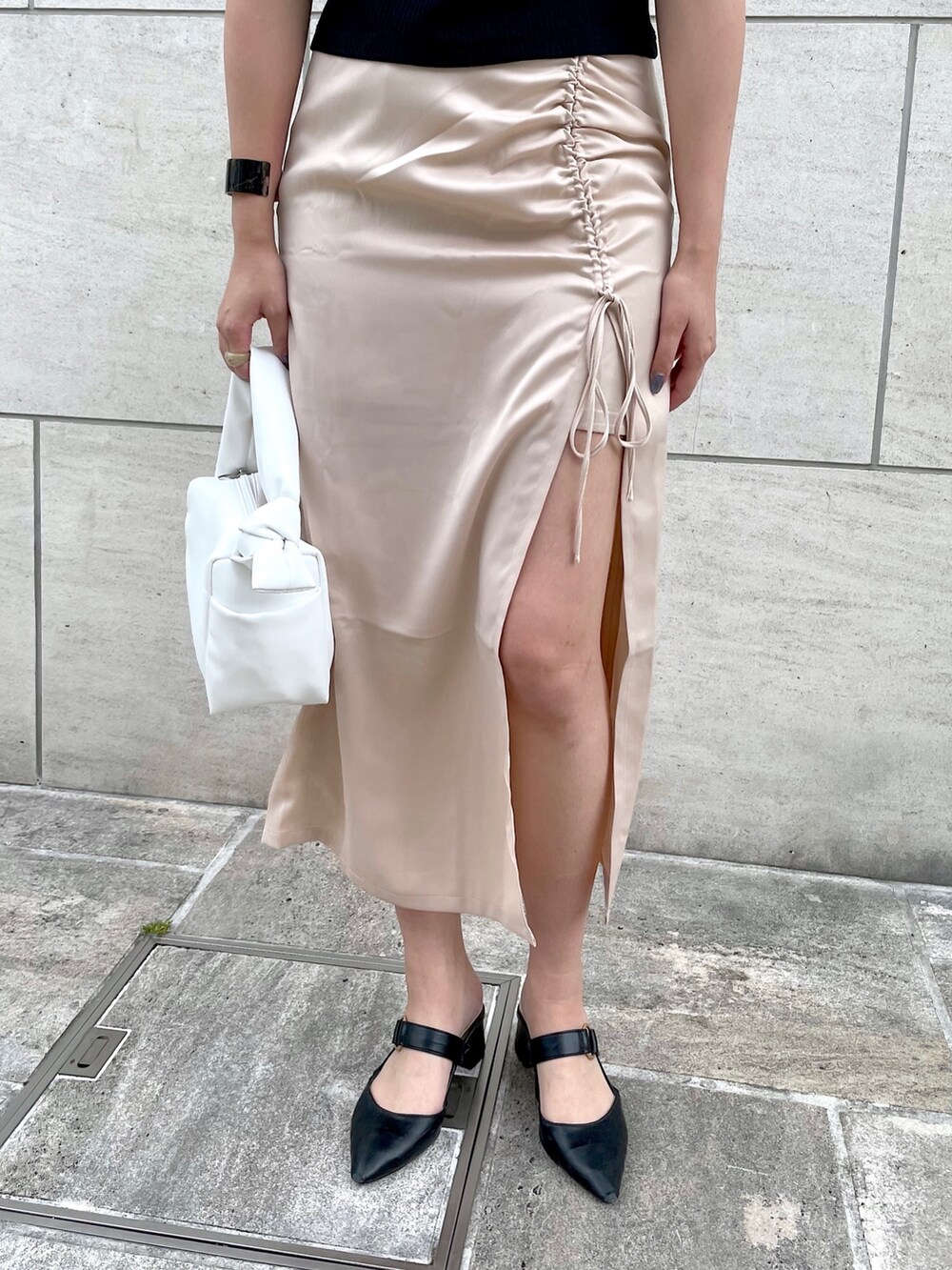 ブラック系のTシャツ/カットソー、ホワイト系のスカート、ホワイト系のショルダーバッグを着用したレディースの夏コーディネートの4枚目の写真