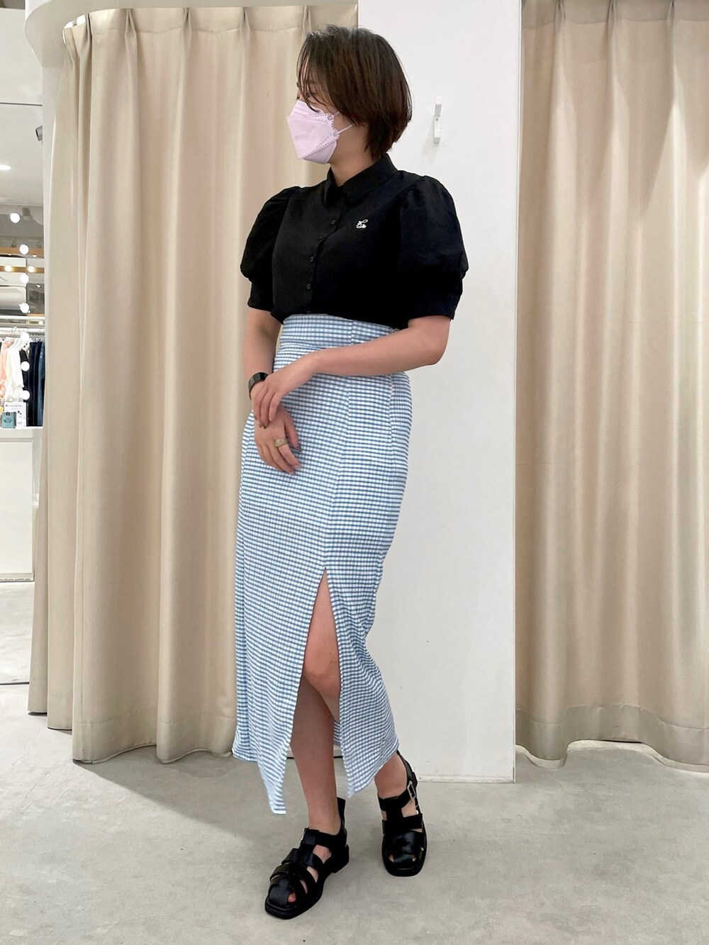 ブラック系のシャツ/ブラウス、ブルー系のスカート、ブラック系のサンダルを着用したレディースの夏コーディネートの2枚目の写真