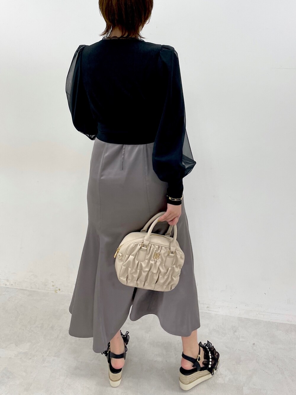 ブラック系のワンピース、ブラック系のサンダルを着用したレディースの冬コーディネートの3枚目の写真