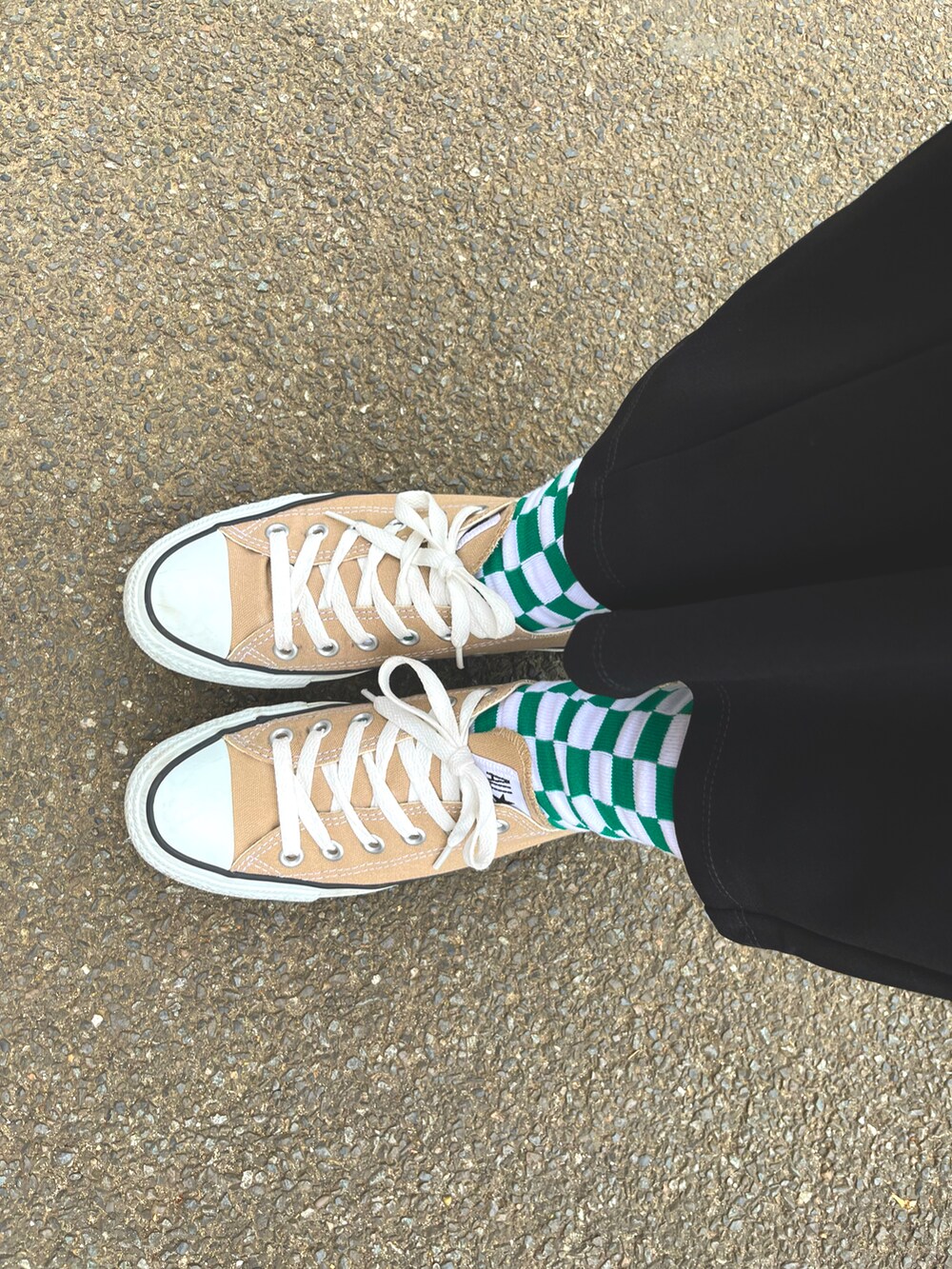 ブラック系のパンツ、ベージュ系のスニーカー、グリーン系のトートバッグを着用したレディースの春コーディネートの3枚目の写真