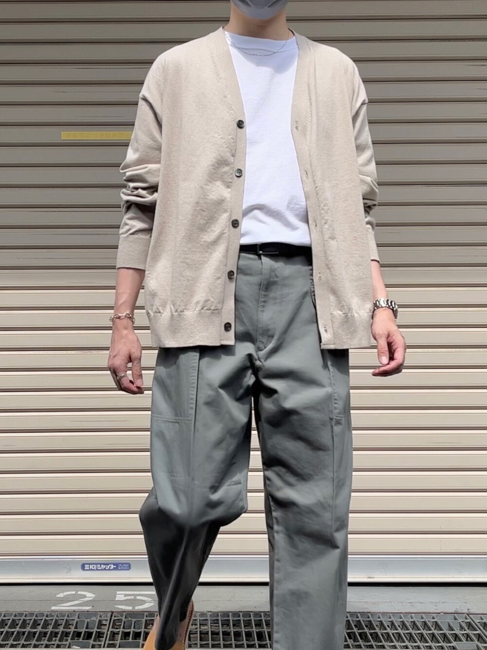 ベージュ系のカーディガン/ボレロ、ホワイト系のTシャツ/カットソー、グリーン系のパンツを着用したメンズの春コーディネートの3枚目の写真