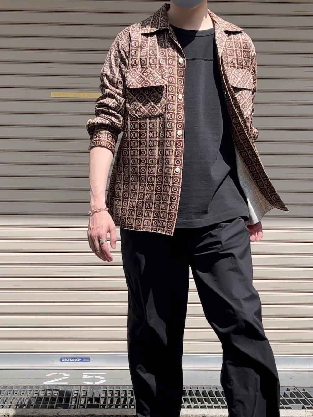 ブラウン系のシャツ/ブラウス、ブラック系のTシャツ/カットソー、ブラック系のスラックスを着用したメンズの春コーディネートの2枚目の写真