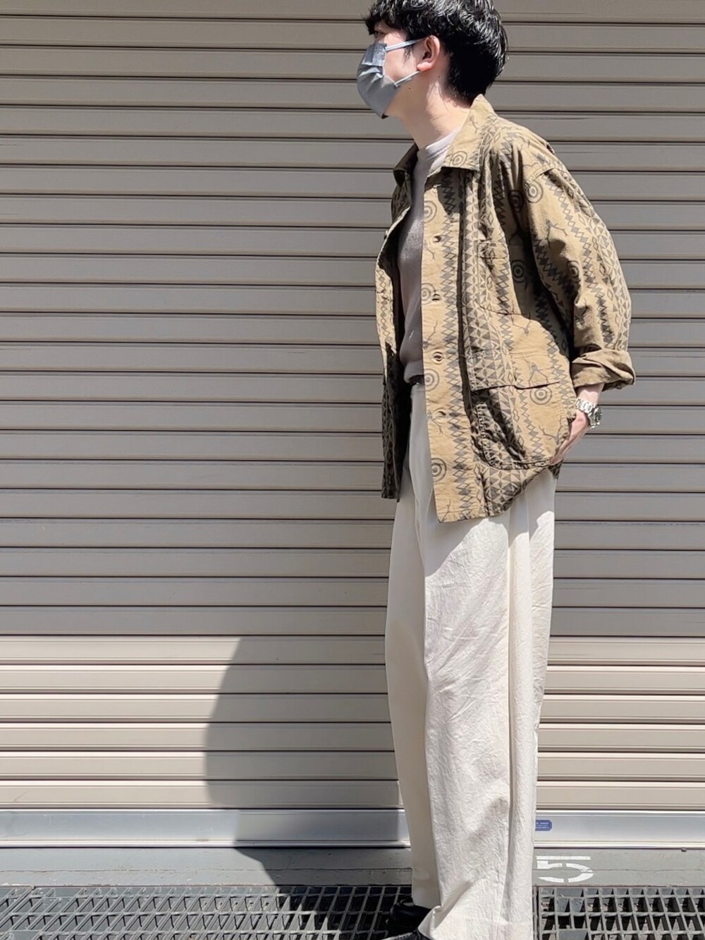 グリーン系のTシャツ/カットソー、ベージュ系のTシャツ/カットソー、ホワイト系のチノパンツを着用したメンズの春コーディネートの2枚目の写真