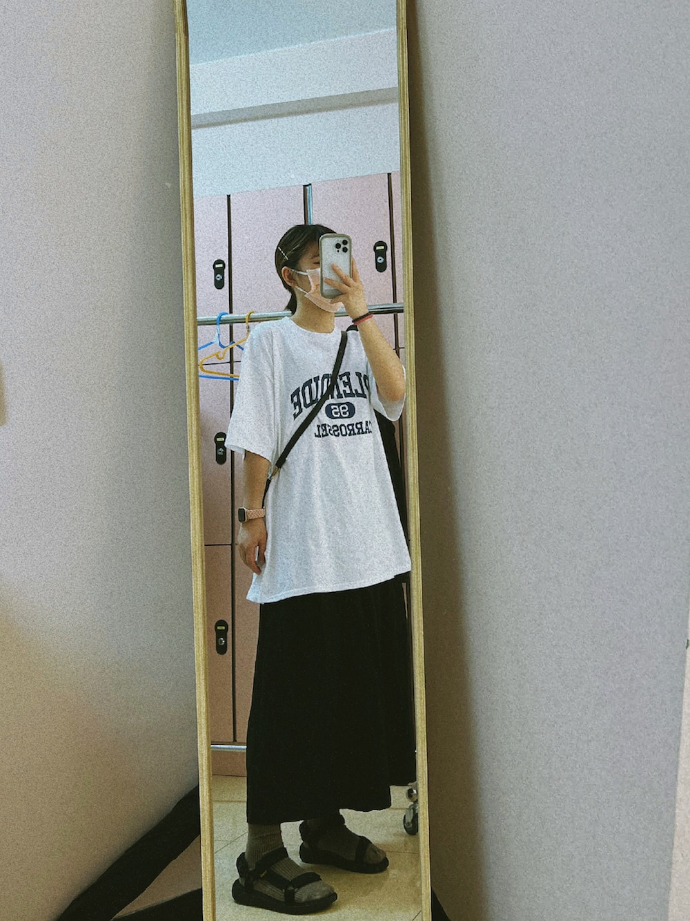 ホワイト系のTシャツ/カットソー、ホワイト系のサンダル、ブラック系のスカートを着用したレディースの秋コーディネートの2枚目の写真