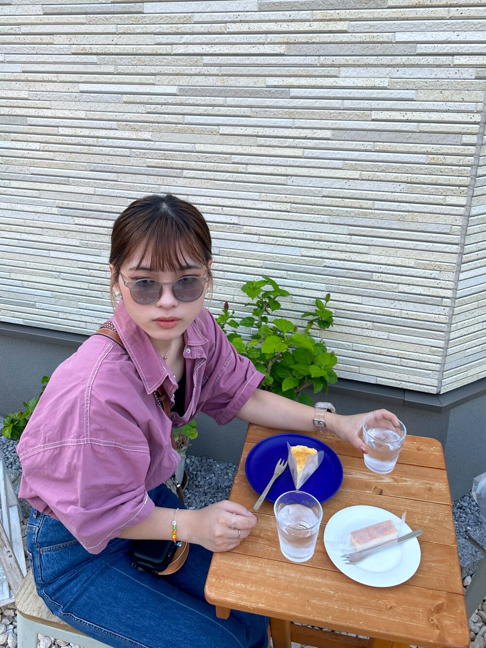 ブルー系のデニムパンツ、ブラック系のサンダル、ブルー系のサングラスを着用したレディースの夏コーディネートの2枚目の写真