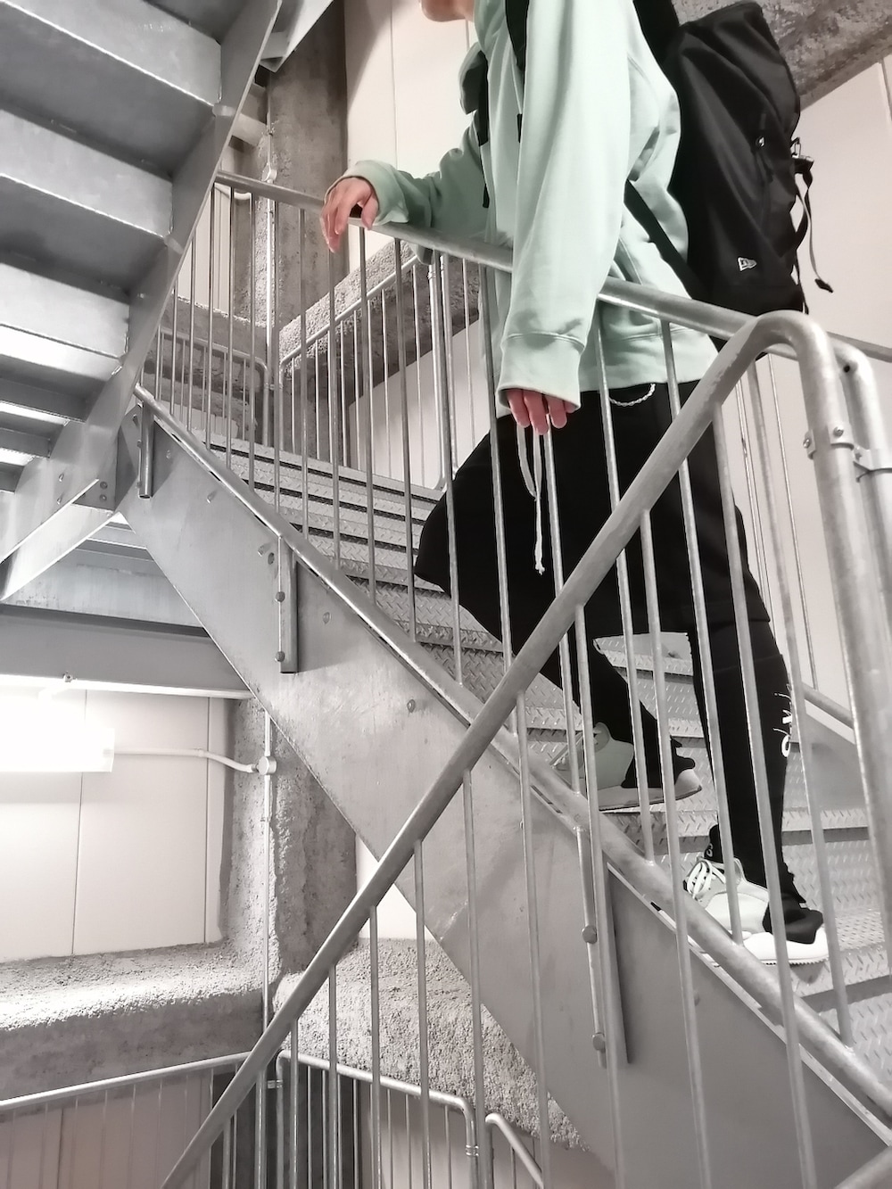 グリーン系のスニーカー、ブラック系のパンツ、グリーン系のパーカーを着用したメンズの春コーディネートの3枚目の写真