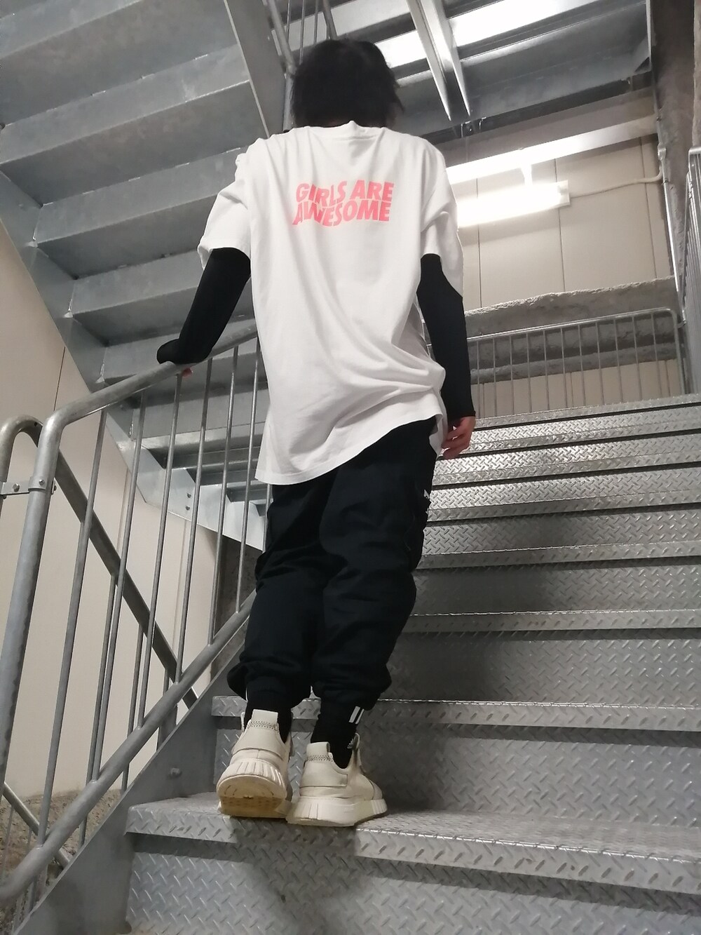 ホワイト系のスニーカー、ブラック系のカーゴパンツ、ホワイト系のトップスを着用したメンズの春コーディネートの4枚目の写真