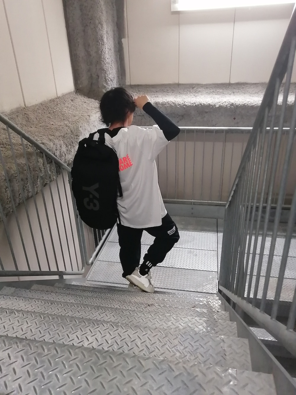 ホワイト系のスニーカー、ブラック系のカーゴパンツ、ホワイト系のトップスを着用したメンズの春コーディネートの2枚目の写真