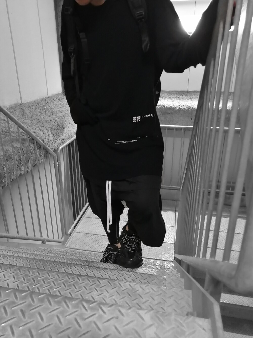 ブラック系のスニーカー、ブラック系のTシャツ/カットソー、ブラック系のパンツを着用したメンズの春コーディネートの4枚目の写真