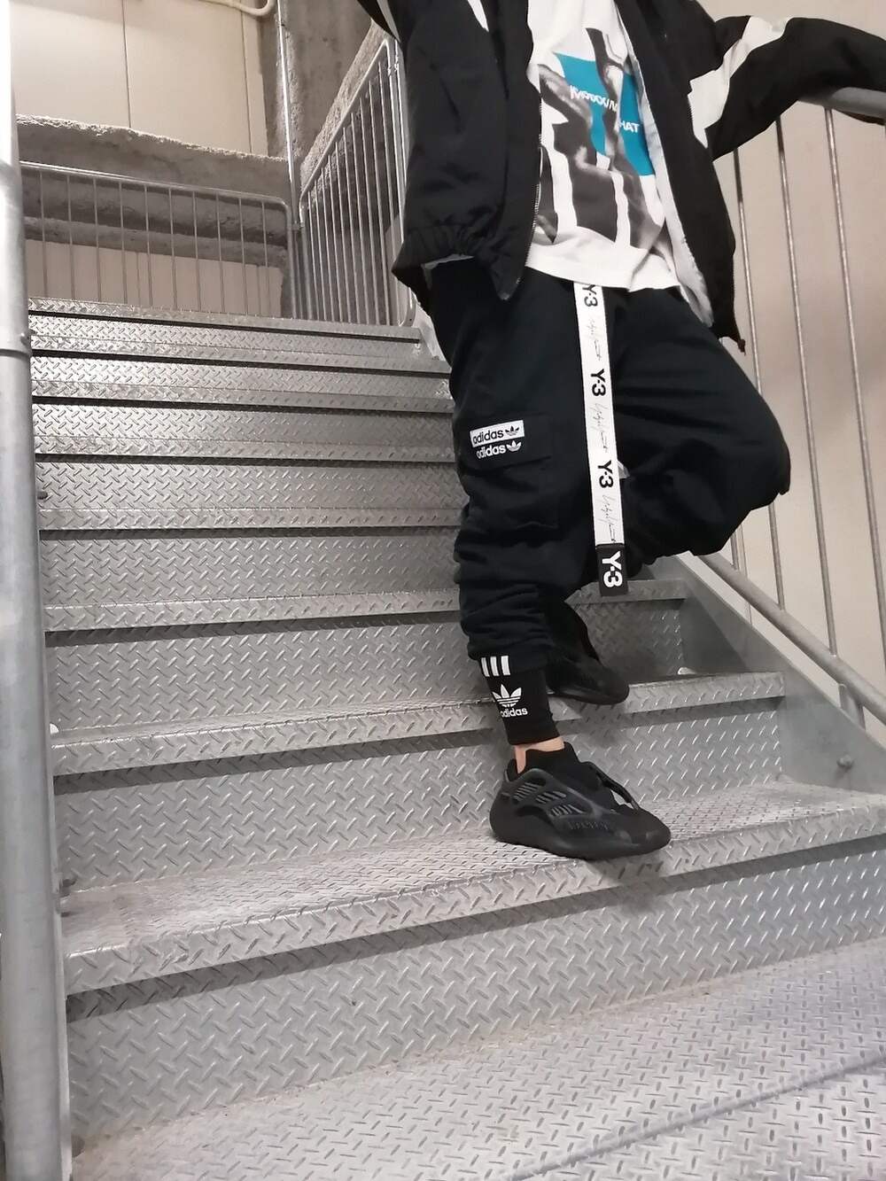 ブラック系のカーゴパンツ、ブラック系のスニーカー、ブラック系のバックパック/リュックを着用したメンズの春コーディネートの5枚目の写真